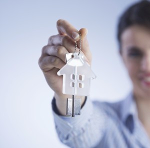 a woman holding up a key for renting a house 